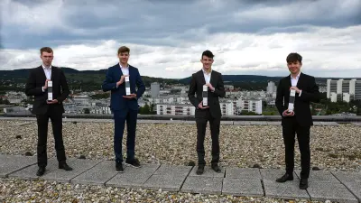 Gewinner des Technik fürs Leben-Preis 2021 in der Kategorie Connected Living: Die Schüler stehen mit ihrer Trophäe in der Hand auf dem Dach der TGM Wien. Im Hintergrund sieht man die Stand Wien.