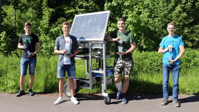 Gewinner des Technik fürs Leben-Preis 2021 in der Kategorie Industrial Technology: Die Schüler stehen mit ihrer Trophäe in der Hand um ihr Siegerprojekt - einem automatisierten Ernteroboter.